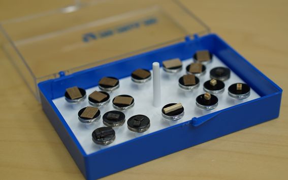 Small different color wood samples placed on sample holders