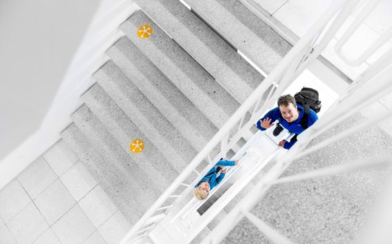 Kuva portaikosta jossa kaksi ihmistä