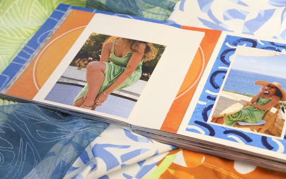 An illustrated book with model wearing summery outfit lays on colourful textiles surface