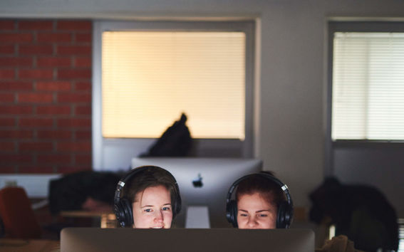 two students behind a screen