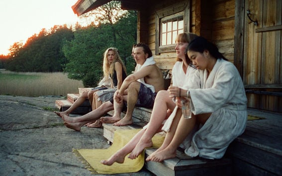 People sitting in front of a cottage after a sauna 