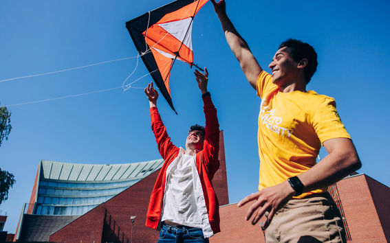 Two guys flying a kite on Otaniemi campus