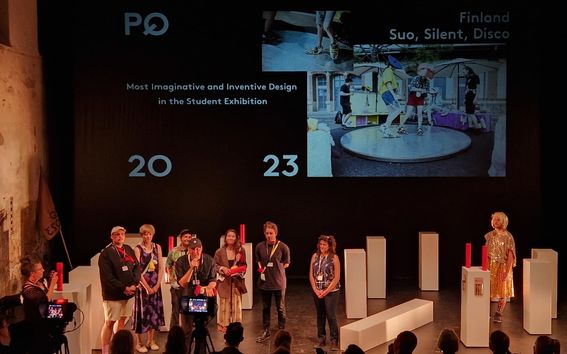 Award ceremony at PQ2023 with nine people onstage