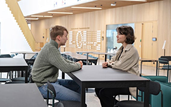 Two students discussing in the School of Business building.