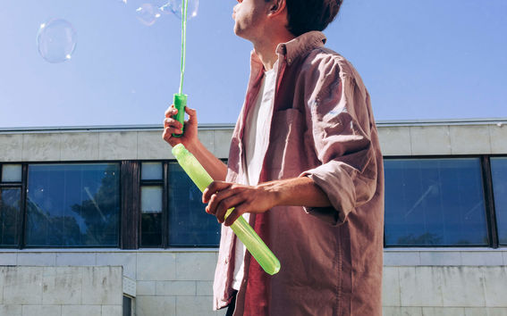 A student is blowing a dandelion.