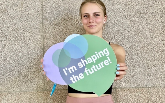 Aalto University student Inka Viita holding a sign that says I'm shaping the future at the Unite! Student Festival in Lisbon in July 2023. 