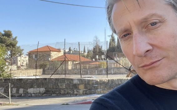 Professor Marco Steinberg in Palestine standing before a barbed wire fence