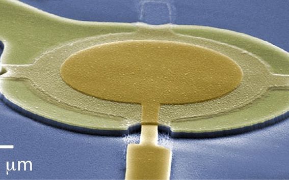 Micro drums enable a nearly noiseless measurement of radio signals. The drum is made of thin superconducting aluminium film on top of a quartz chip (blue background). Image: Mika Sillanpää