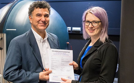 Development Manager Anne Ala-Pöntiö of Orion Diagnostica Oy receives the 1000th calibration certificate from Head of Calibration Services, Dr. Farshid Manoocheri