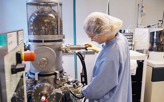Helena Hilander, who works as an assistant in the research team for micro and quantum systems, is preparing the electron beam evaporator machine, which is used for the metallic covering of samples.
