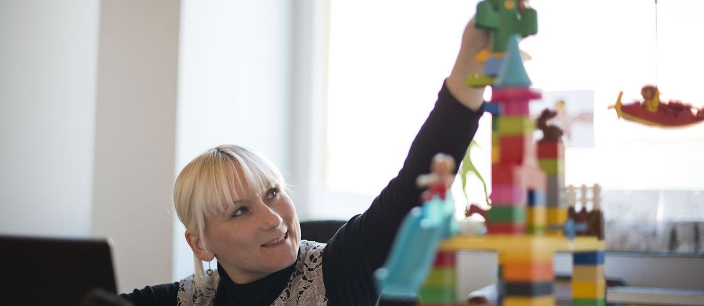 Pauliina Ilmonen rakentaa tornia lego-palikoista kuvattuna työhuoneessaan. Kuva: Heidi-Hanna Karhu.