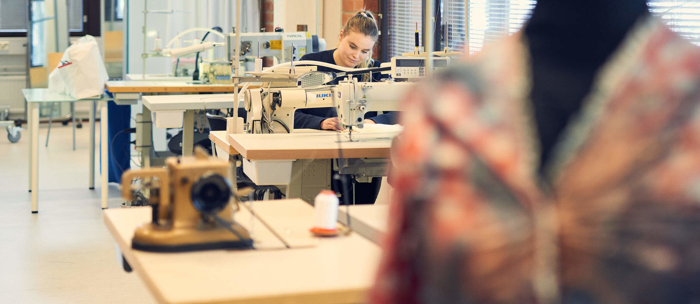 Woman sewing fabric at the School of Arts, Design & Architecture