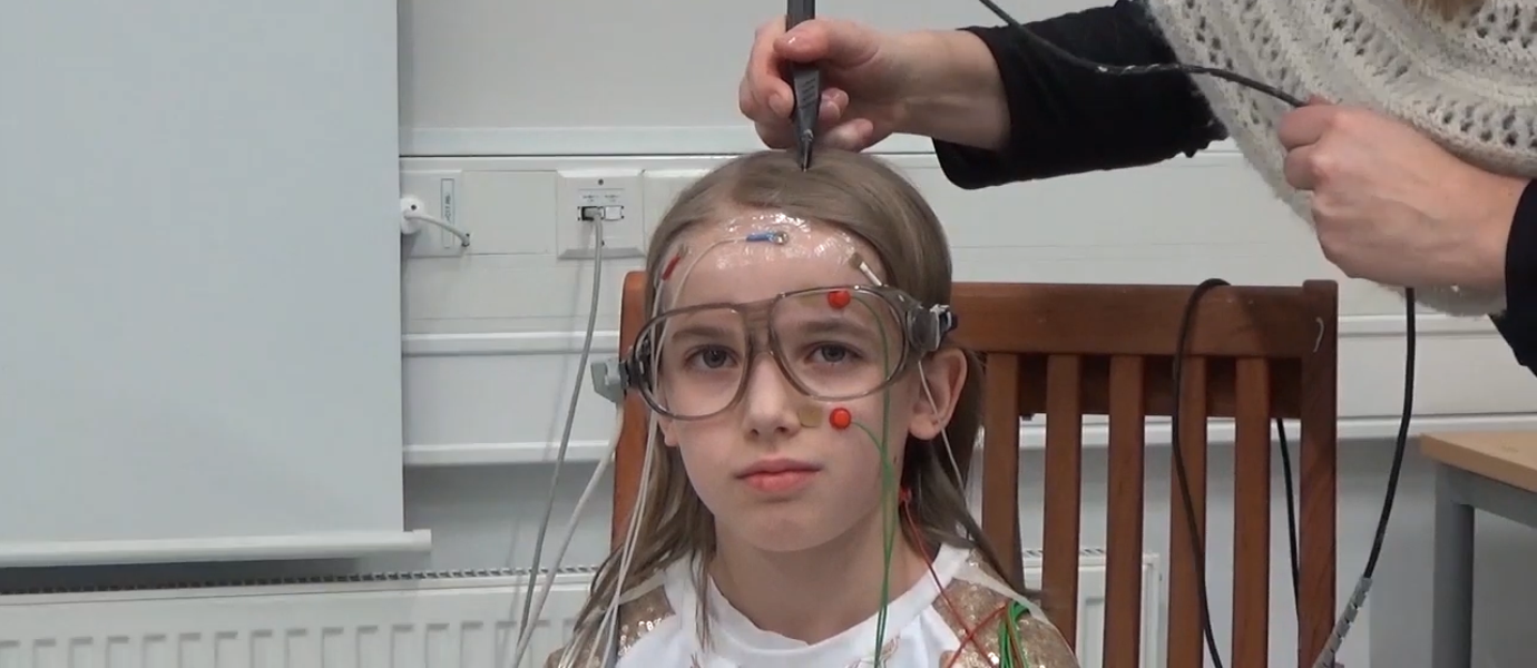 Magnetoencephalography (MEG) was used to study reading difficulties in children. This photo shows preparations for the measurement test. The child in the photo was not part of the study. Picture : Aalto University.