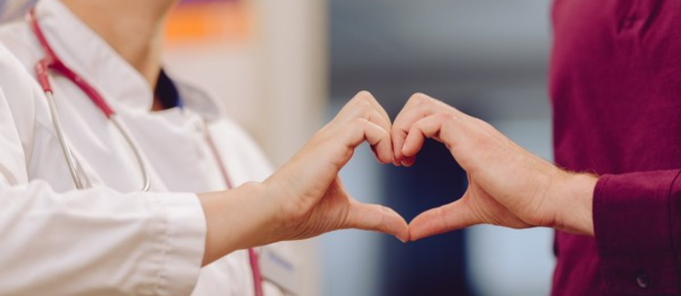 Doctor patient encounter with hands forming a heart