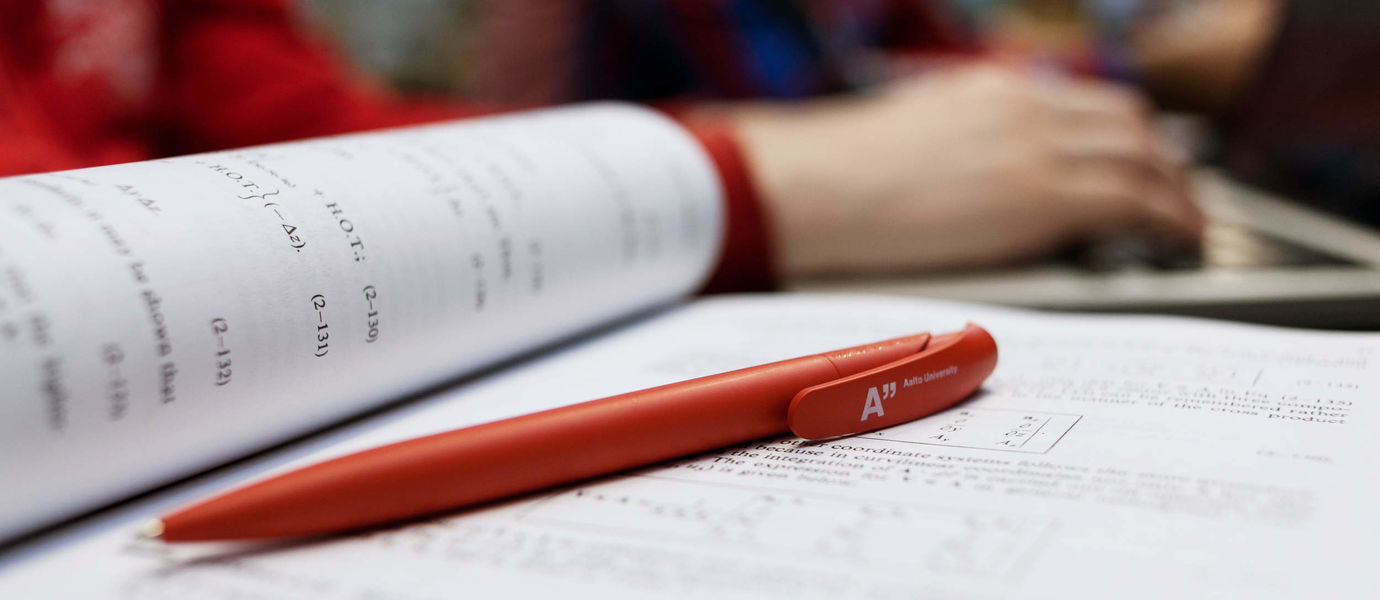 Aalto University red pen and notebook