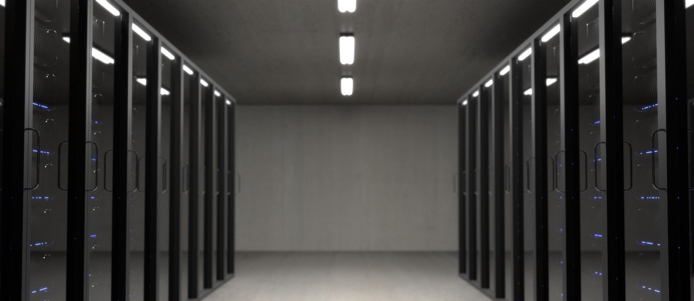view of gray room with floor to ceiling dark windowed servers racks on both sides