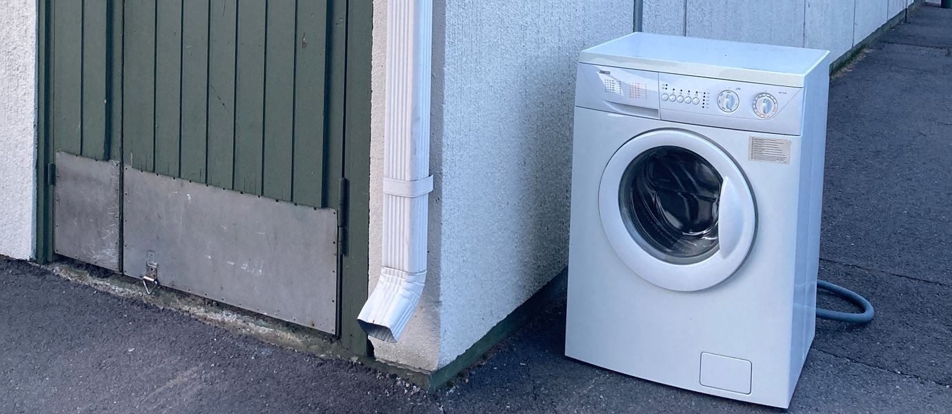 A photo of a corner with a door and a washing machine.