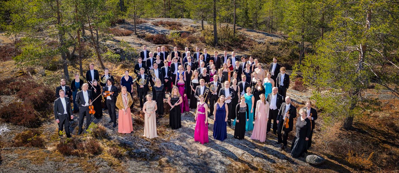 Players of Polytech Orchestra photographed in summertime on a cliff in the woods