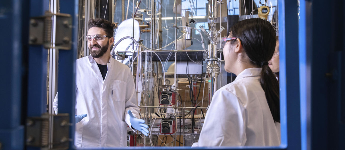 Kaksi henkilöä laboratoriossa valkoiset takit yllään.