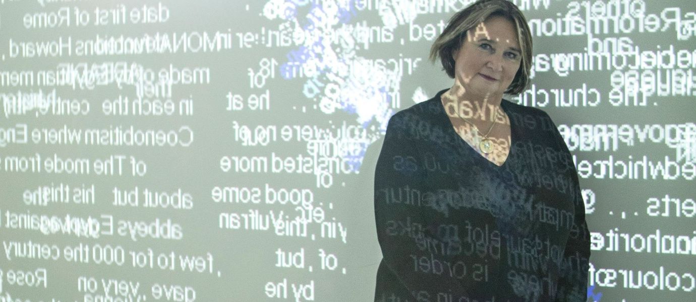 Rafaela Seppälä seisoo keskellä valoteosta, joka muodostuu seinälle heijastetuista englanninkielisistä sanoista. Sanoja kulkee myös Seppälän kasvojen ja vartalon päältä.