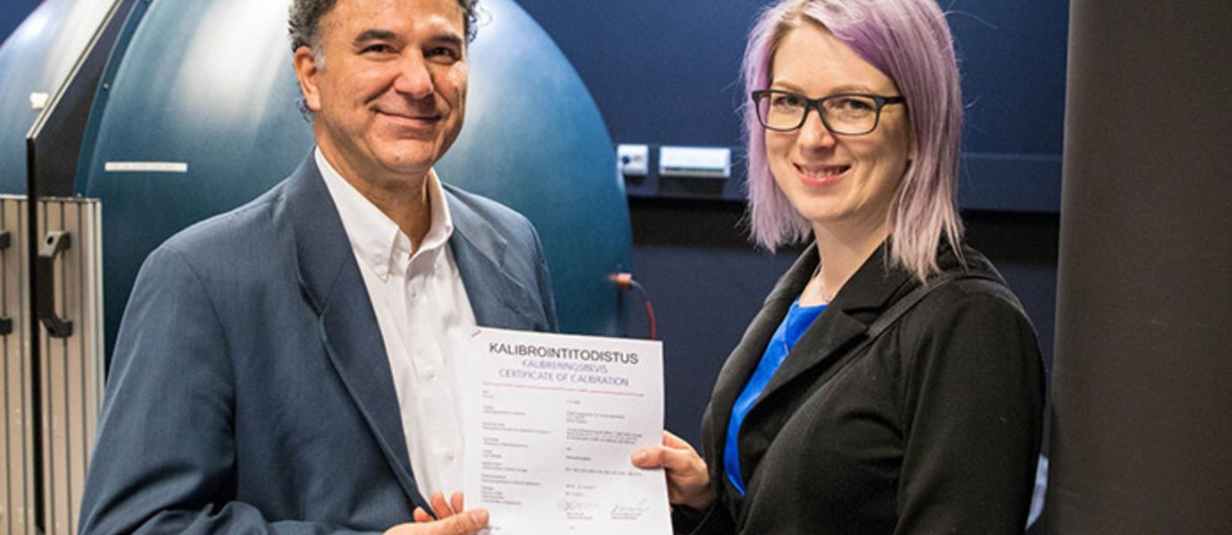 Development Manager Anne Ala-Pöntiö of Orion Diagnostica Oy receives the 1000th calibration certificate from Head of Calibration Services, Dr. Farshid Manoocheri