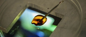 Orange liquid on the surface of a microscope slide / photo by Aalto University, Mikko Raskinen