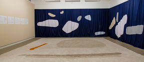 Photo of an art installation consisting of tapestry and fabrics in a gallery space