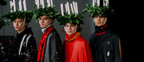 three models wearing candle headpieces and capes