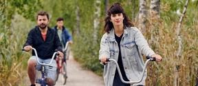 Opiskelijoita pyöräilemässä kampuksella. 