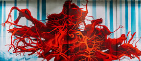 Saara Salmi painting in Keran Hallit. Deep red roots spread out across the wall