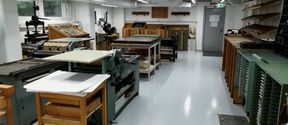 A printshop space with letterpress machines and typeface drawers, from printmaking workshop