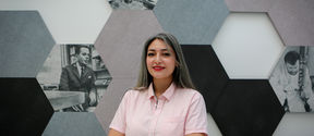 Sanaz Zarabi in the middle of frame with hexagonal artwork behind her.