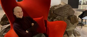Santeri Kokkonen sitting on a red armchair at Dipoli.