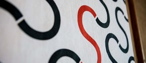 Photo of a part of a painting with letters S painted on white background