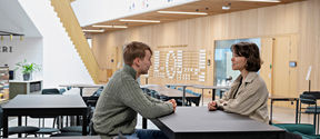 Two students discussing in the School of Business building.