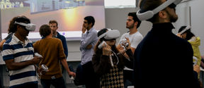People at a VR event, some are wearing the VR headsets and and holding the motion controllers