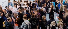 Crowd of people networking at a career fair.