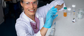 Professor Jaana Vapaavuori wearing a lab coat and safety glasses.