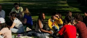 A group of Aalto University Summer School students during a welcome picnic in the park outside Aalto University campus.