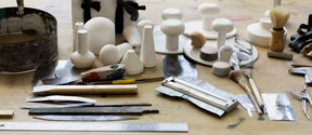 Workshop table full of tools for working with plaster and clay