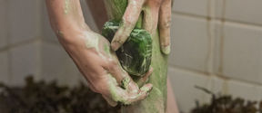 Taking a shower with a green foamy soap, algae in the background