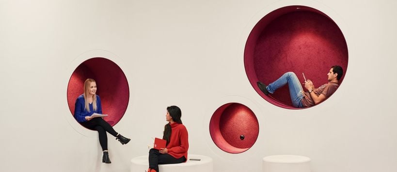 People sitting in round holes in walls. Photo by Unto Rautio / Aalto University.