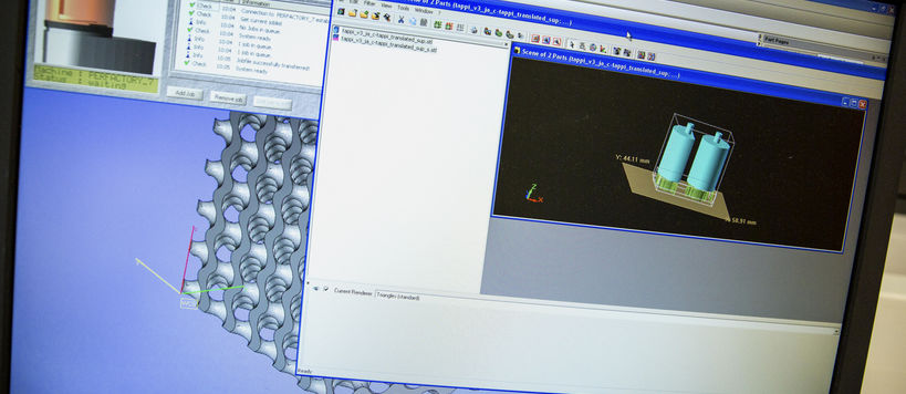 Computer screen with several windows open, showing cylindrical shapes on topmost windoe and three-dimensional grid structure underneath it. Photo by Mikko Raskinen.