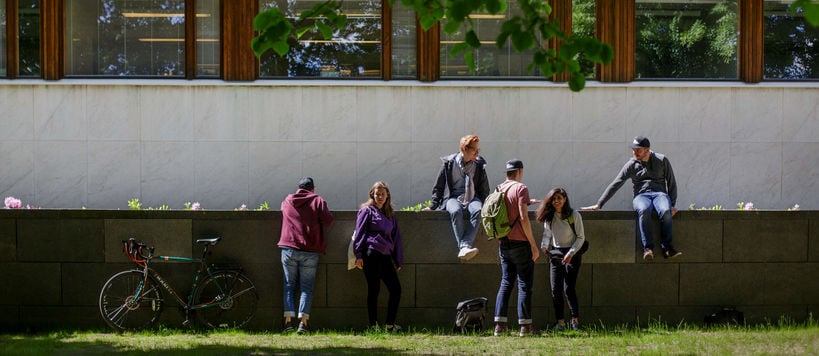 A group of students sat on a wall