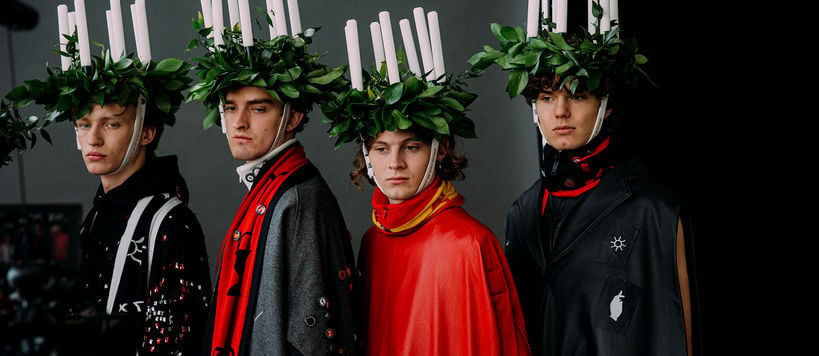 three models wearing candle headpieces and capes