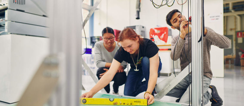 Three Aalto University students working on 3D printing on the Otaniemi campus.