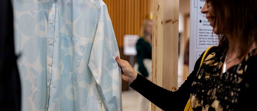 Woman touching a long-sleeved Marimekko Unikko shirt on display