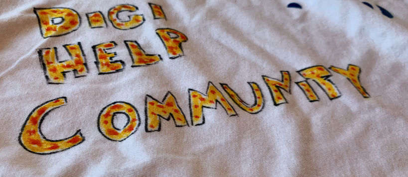 A white t-shirt with Digi help community written with yellow and red markers.