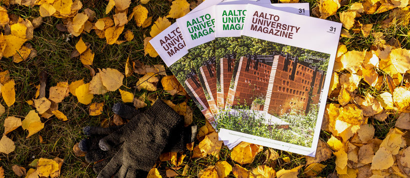 Neljä Aalto University Magazinea syksyisellä nurmikolla keltaisten lehtien päällä. Julkaisujen vieressä on mustat neulehansikkaat.