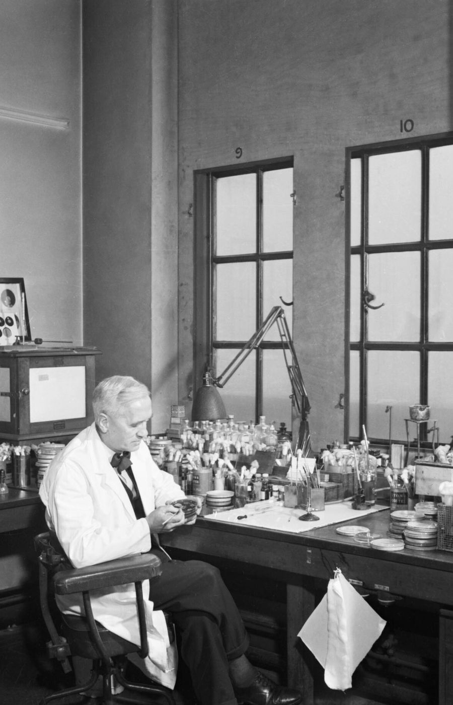 an old black and white picture of Professor Fleming sitting in his lab